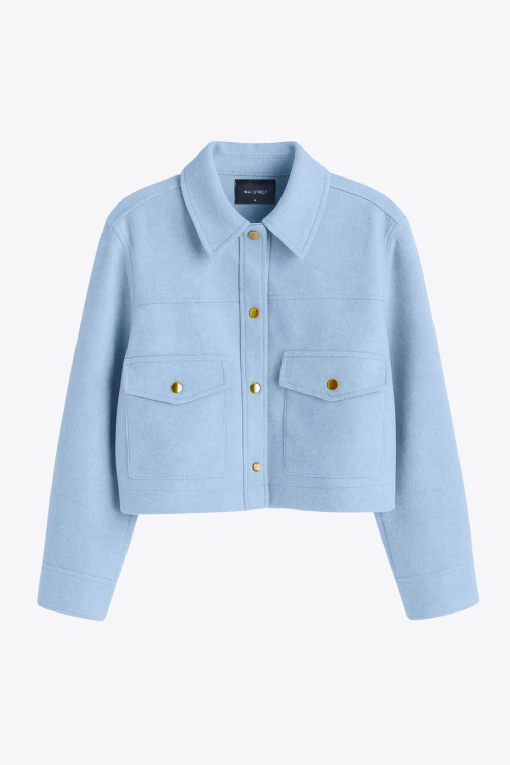 Chamarra corta de fit recto, cuello camisero, manga larga con puño abotonado, cortes decorativos frontales, bolsillos delanteros con cartera y botón. Cierre frontal con hilera de botones en contraste.