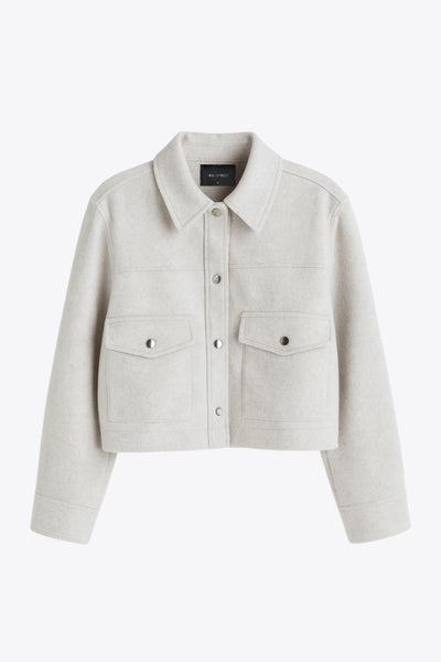 Chamarra corta de fit recto, cuello camisero, manga larga con puño abotonado, cortes decorativos frontales, bolsillos delanteros con cartera y botón. Cierre frontal con hilera de botones en contraste.