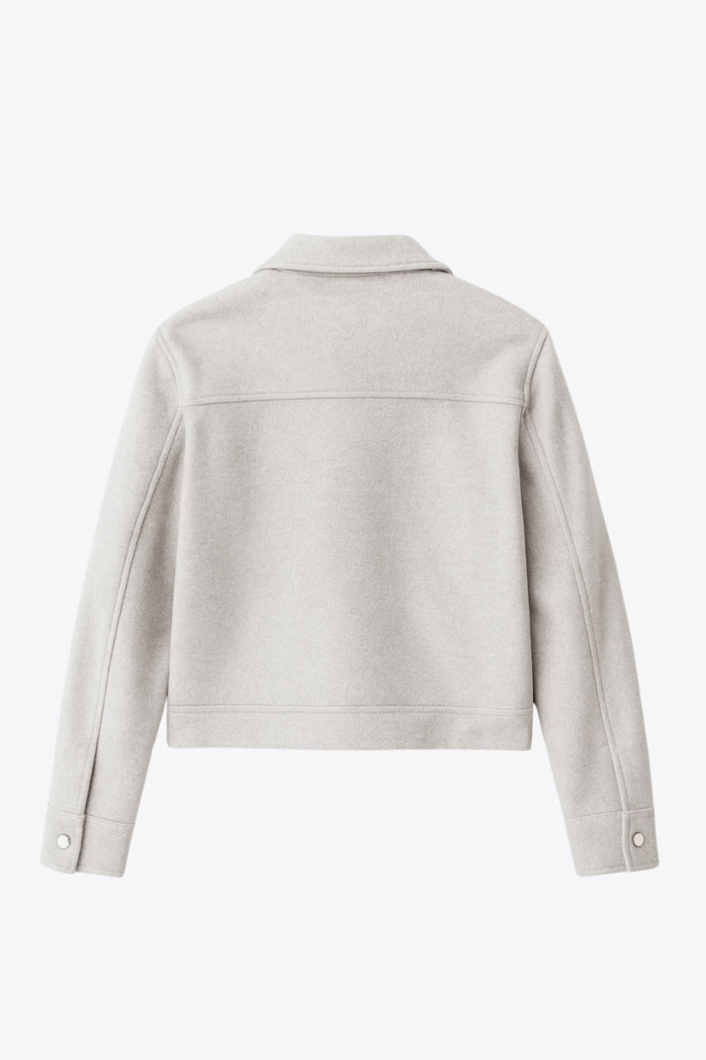 Chamarra corta de fit recto, cuello camisero, manga larga con puño abotonado, cortes decorativos frontales, bolsillos delanteros con cartera y botón. Cierre frontal con hilera de botones en contraste.