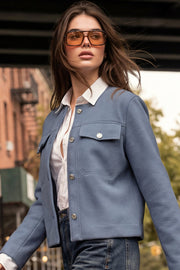 Blazer corto de cuello redondo, bolsillos decorativos con solapa y botón en contraste, fit recto, manga larga y cierre frontal con hilera de botones en contraste.