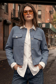 Blazer corto de cuello redondo, bolsillos decorativos con solapa y botón en contraste, fit recto, manga larga y cierre frontal con hilera de botones en contraste.