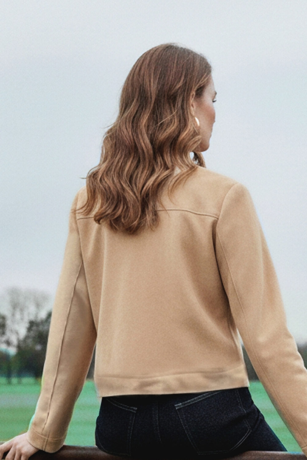 Blazer corto de gamuza, cuello redondo, bolsillos frontales con solapa y botón en contraste, fit recto, manga larga y cierre frontal con hilera de botones en contraste.