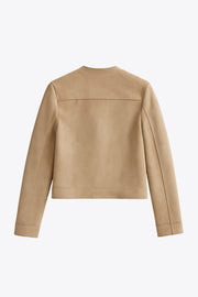 Blazer corto de gamuza, cuello redondo, bolsillos frontales con solapa y botón en contraste, fit recto, manga larga y cierre frontal con hilera de botones en contraste.