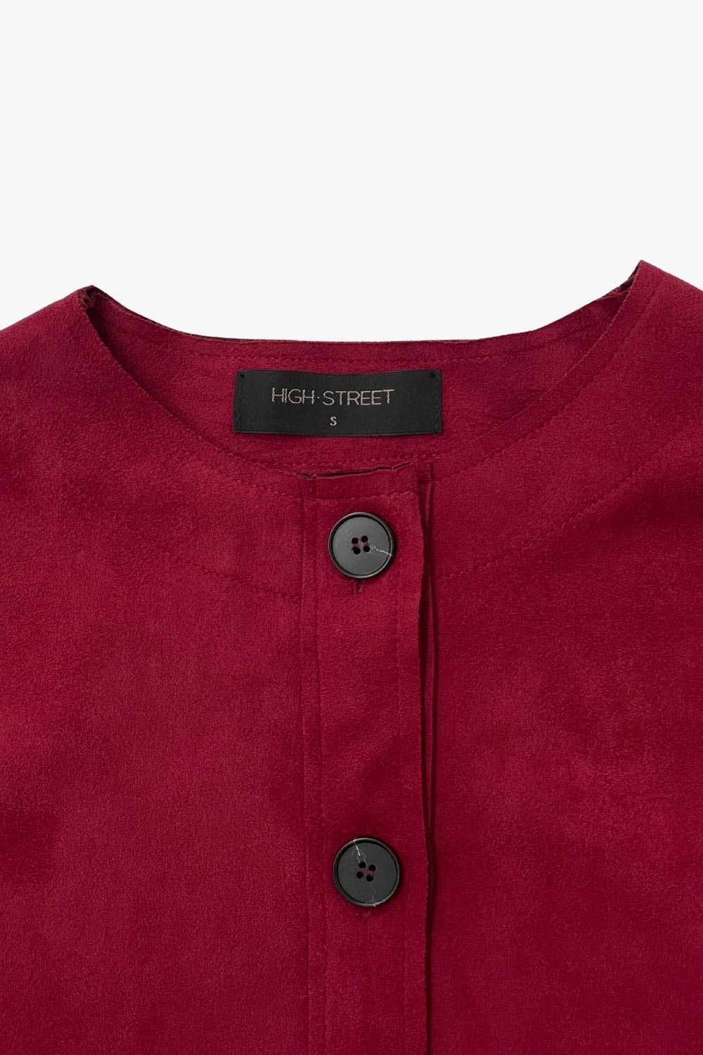 Blazer corto de gamuza, cuello redondo, bolsillos frontales con solapa y botón en contraste, fit recto, manga larga y cierre frontal con hilera de botones en contraste.