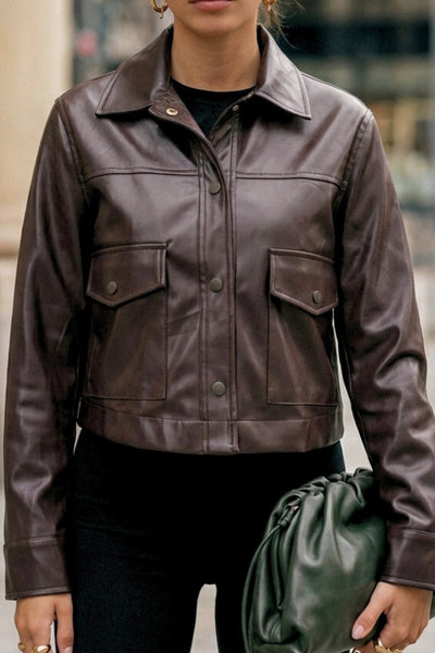 Chamarra corta de efecto piel, fit recto, cuello camisero, manga larga con puño abotonado, bolsillos delanteros de parche con cartera y botón. Cierre frontal con hilera de botones.