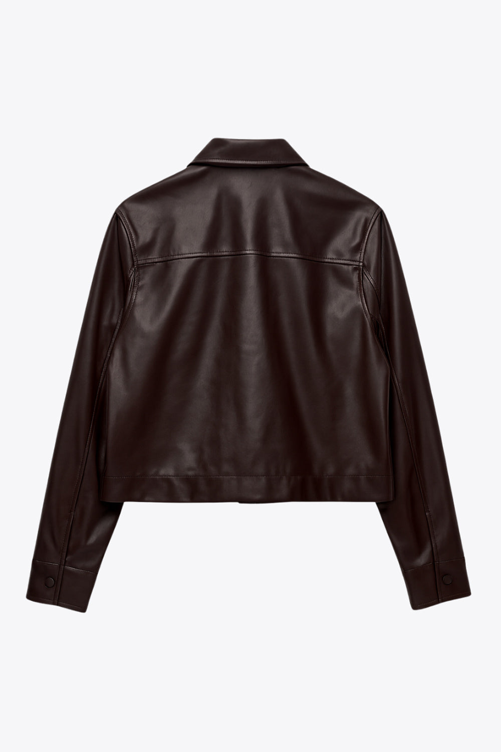 Chamarra corta de efecto piel, fit recto, cuello camisero, manga larga con puño abotonado, bolsillos delanteros de parche con cartera y botón. Cierre frontal con hilera de botones.