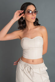 Corset de efecto piel, fit ajustado, escote corazón, costuras frontales decorativas y cierre posterior con cremallera visible en contraste.