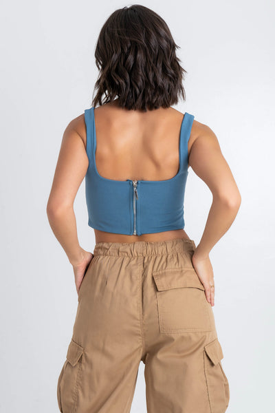 Crop top de fit ajustado, escote cuadrado, tirantes y cut out frontal en cintura. Cierre posterior con cremallera visible en contraste.
