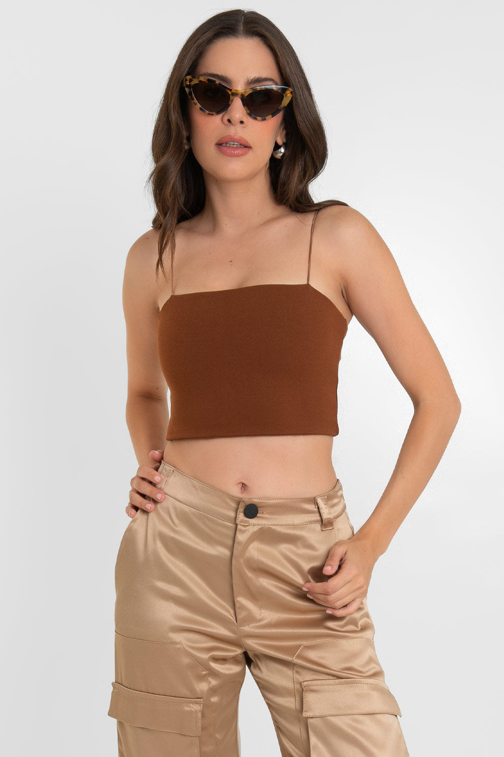 Crop top bandeau de fit ajustado, escote recto y tirantes delgados elásticos. Cierre posterior con cremallera visible.