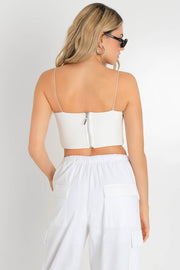 Crop top bandeau de fit ajustado, escote recto y tirantes delgados elásticos. Cierre posterior con cremallera visible.