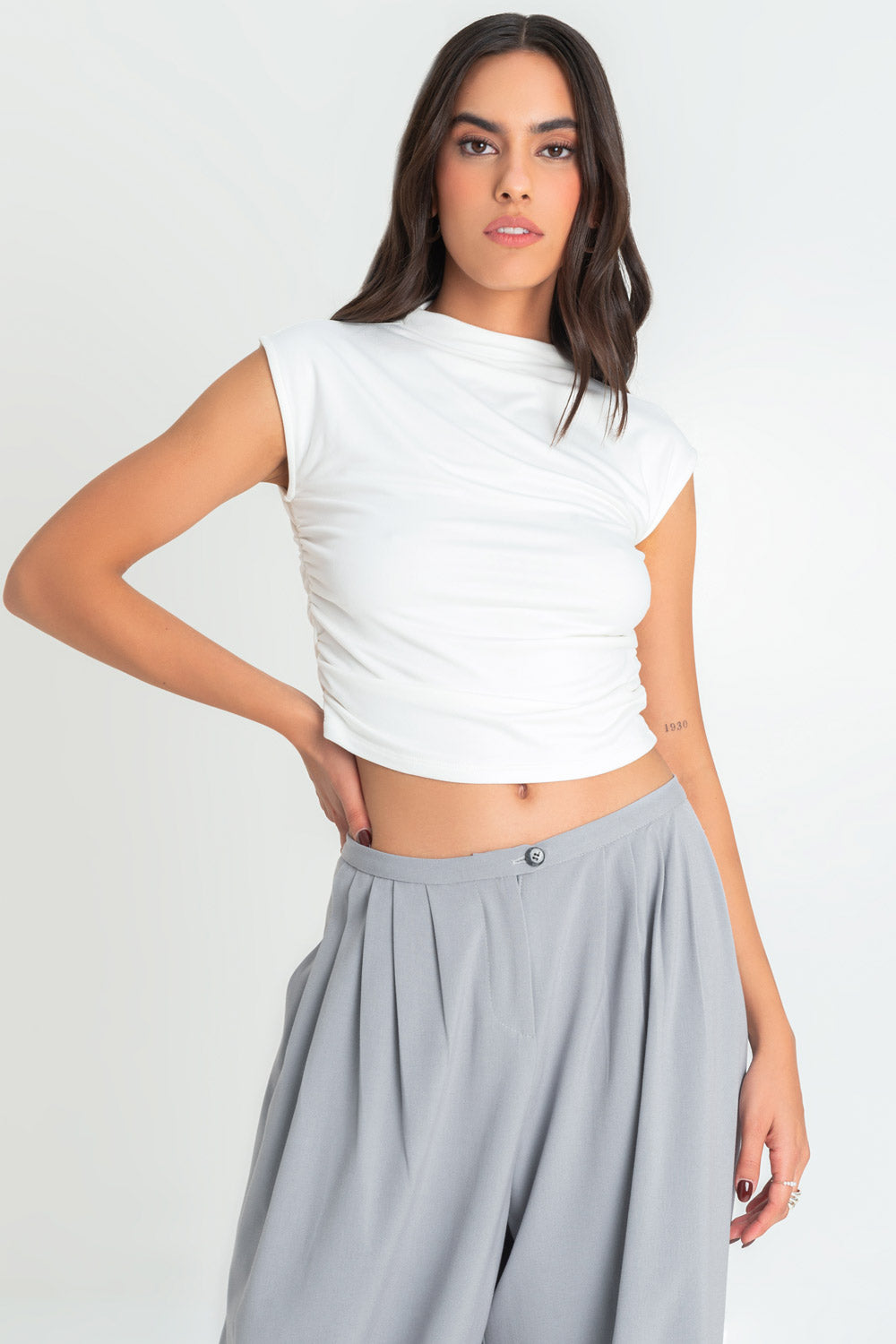 Crop top de fit ajustado, cuello mock seguido, manga corta seguida, fit ajustado y detalles plisados en costados.