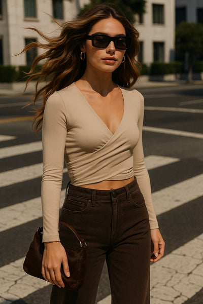 Crop top de escote v cruzado con plisados frontales, manga larga y fit ajustado.