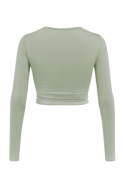 Crop top de escote v cruzado con plisados frontales, manga larga y fit ajustado.