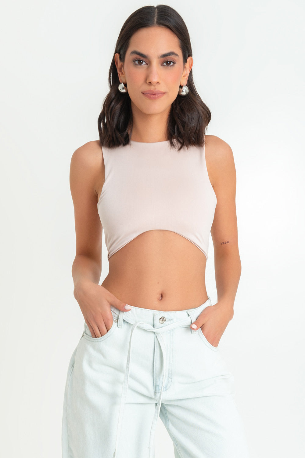 Crop top satinado de fit ajustado, sin mangas, cuello redondo y bajo frontal curveado.