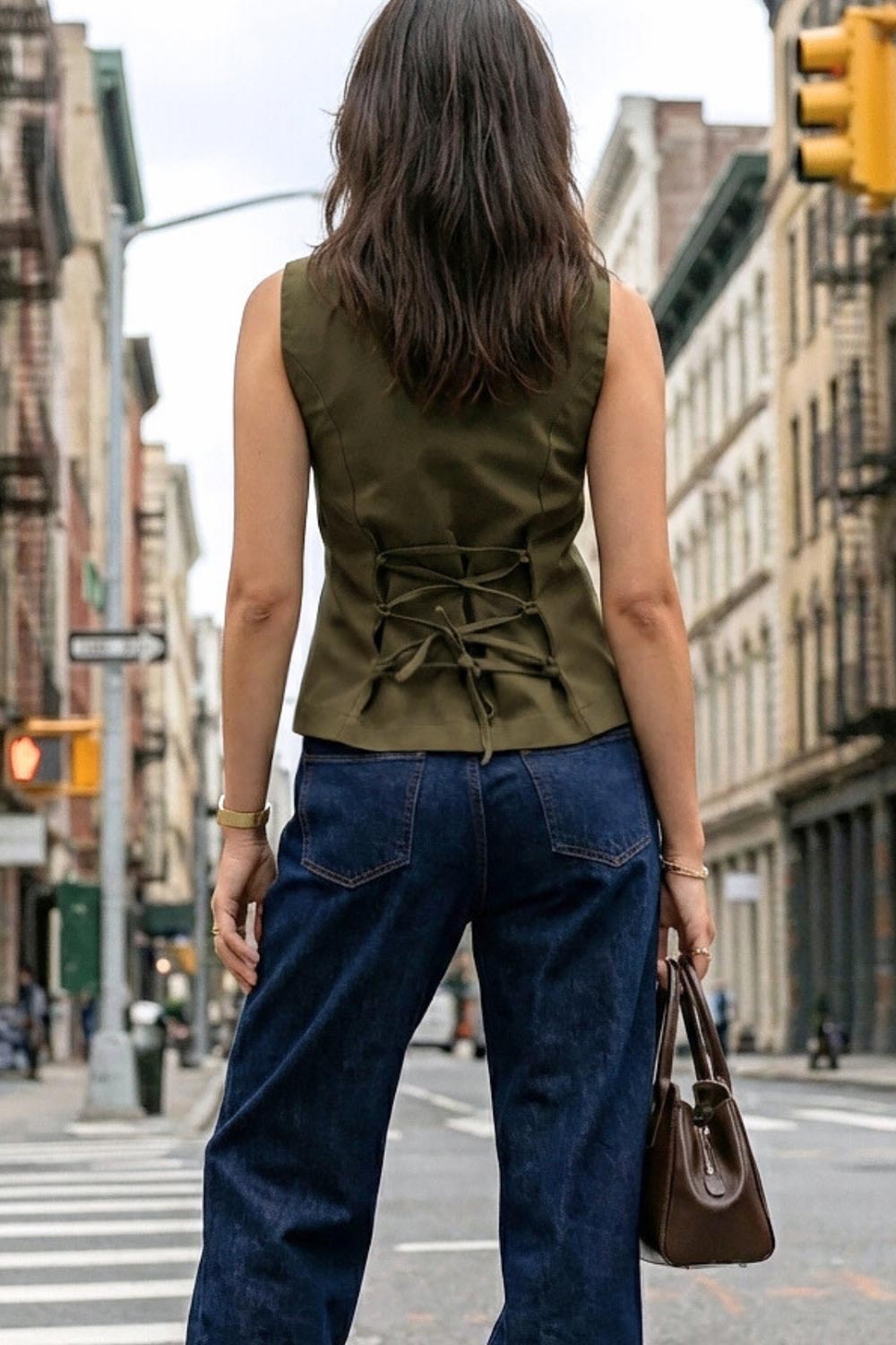 Chaleco de fit ajustado, cuello redondo, cierre frontal con hilera de botones en contraste, con abertura frontal en bajo y detalle de lazado ajustable en espalda.