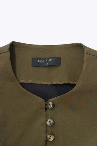 Chaleco de fit ajustado, cuello redondo, cierre frontal con hilera de botones en contraste, con abertura frontal en bajo y detalle de lazado ajustable en espalda.