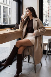 Falda short corto de bouclé, fit ajustado, cintura alta, vivos decorativos posteriores y cierre lateral con cremallera oculta.