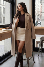 Falda short corto de bouclé, fit ajustado, cintura alta, vivos decorativos posteriores y cierre lateral con cremallera oculta.