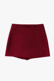 Falda short corto de bouclé, fit ajustado, cintura alta, vivos decorativos posteriores y cierre lateral con cremallera oculta.