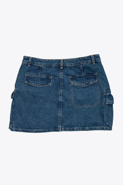 Falda corta cargo de denim, fit ajustado, cintura media con pretina y trabillas, bolsillos delanteros, laterales y posteriores cargo con cartera. Cierre frontal con cremallera oculta y botón en contraste.