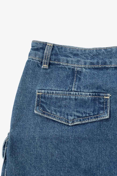 Falda corta cargo de denim, fit ajustado, cintura media con pretina y trabillas, bolsillos delanteros, laterales y posteriores cargo con cartera. Cierre frontal con cremallera oculta y botón en contraste.