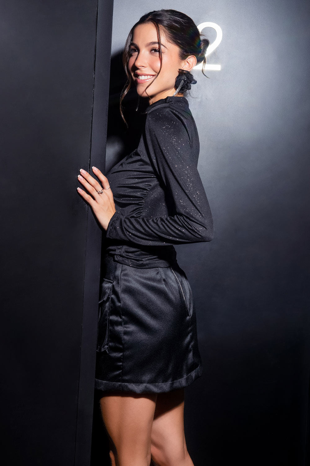 Falda corta satinada de fit recto, cintura alta, fit recto, bolsillos frontales cargo con cartera y cierre posterior con cremallera visible en contraste.