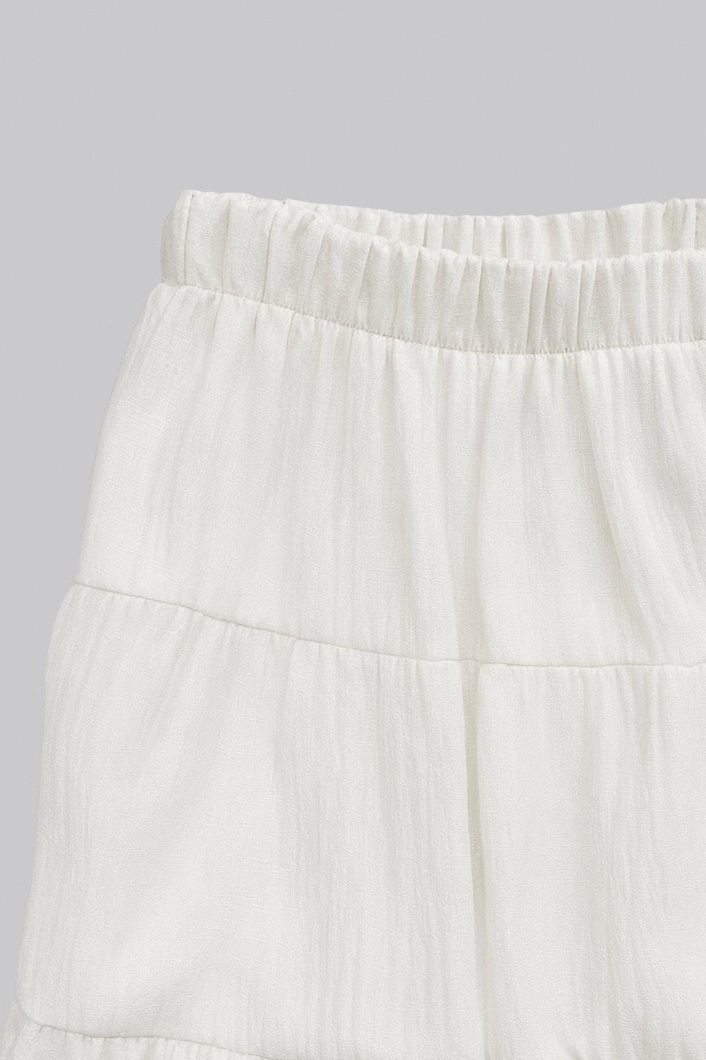 Falda maxi de cintura media con pretina elástica, corte en a y capas de olanes en bajo.