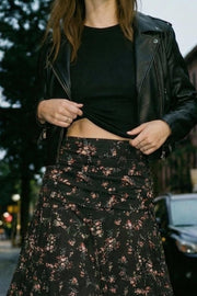 Falda maxi de estampado floral, corte en a, cintura alta con detalle plisados y olanes en bajo. Cierre lateral con cremallera oculta.