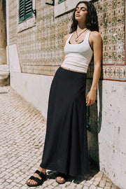 Falda midi de cintura media, corte en a, con cortes decorativos y cierre lateral con hilera de botones.