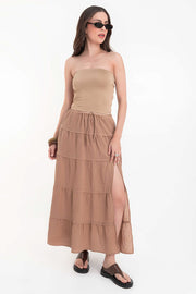 Falda maxi de cintura alta con pretina elástica y jareta frontal ajustable, corte en a, capas de olanes en bajo y abertura lateral.