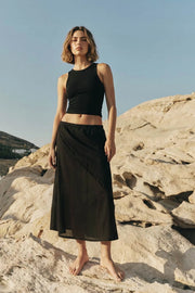 Falda midi de lino, cintura baja elástica y detalle de costura decorativa frontal en diagonal.