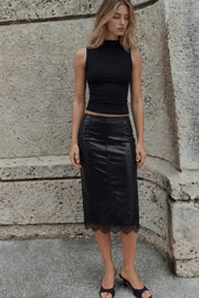 Falda midi de efecto piel, fit ajustado, cintura media, cortes decorativos, abertura lateral en bajo y encaje decorativo en borde. Cierre lateral con cremallera oculta.