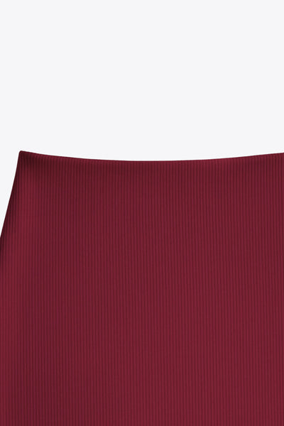 Falda midi de fit ajustado, cintura media elástica, abertura lateral en bajo y detalle de textura en tejido.