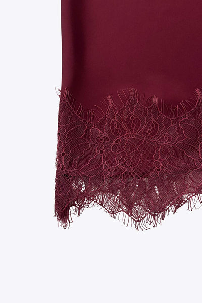 Falda midi satinada de cintura alta con pretina elástica y fit recto. Detalle de encaje en bajo.