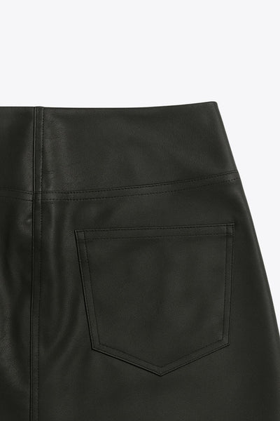 Falda corta de efecto piel, fit ajustado, cintura alta, costuras frontales decorativas, bolsillos delanteros y traseros de parche. Cierre frontal con cremallera oculta.