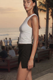 Falda short corto de cintura alta elástica y cruce frontal asimétrico con plisados laterales.