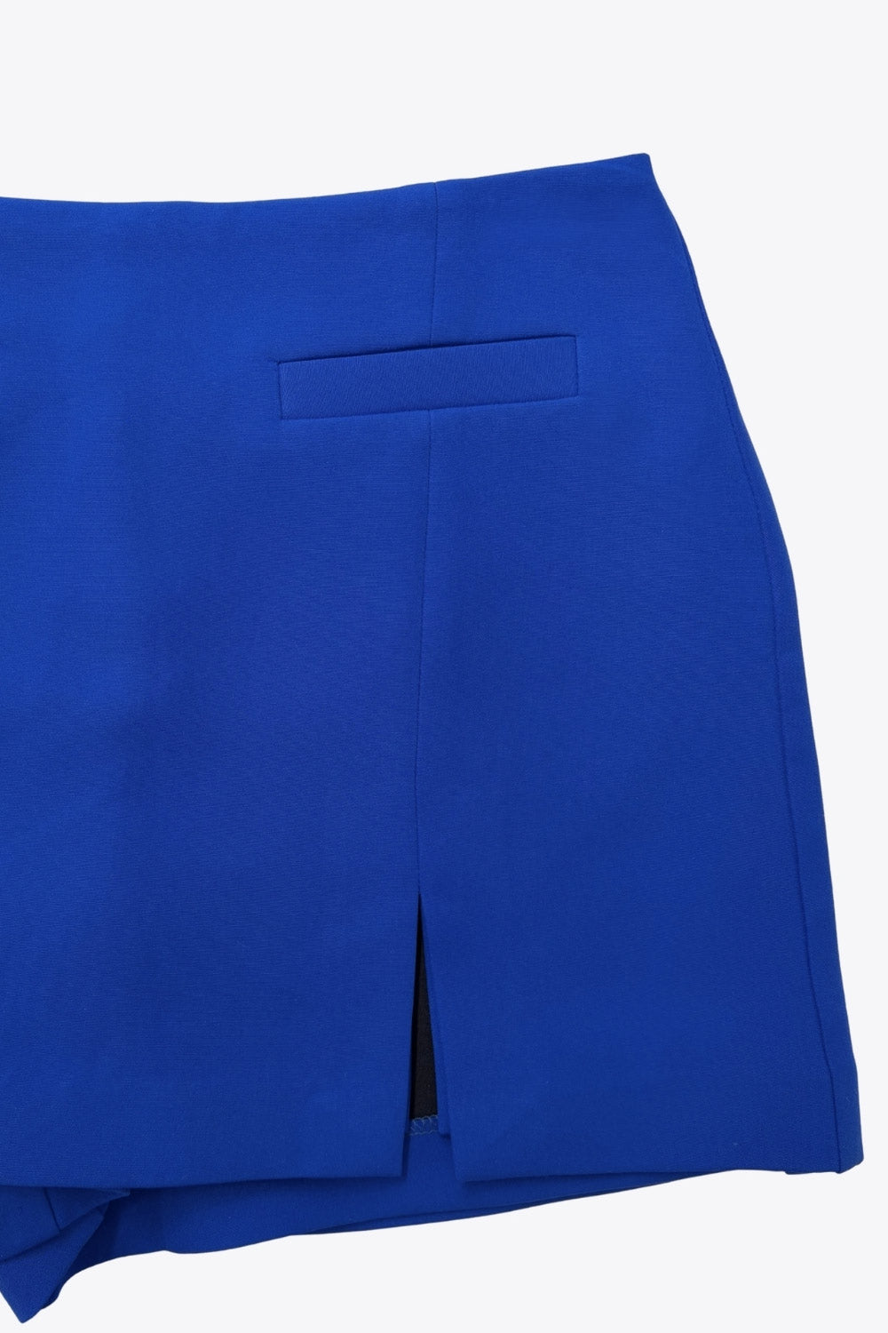 Falda short de fit ajustado cintura alta, vivos decorativos frontales, abertura en bajo y cierre posterior con cremallera oculta.