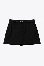 Falda short corto de fit recto, cintura alta con pretina y trabillas, vivos decorativos posteriores, cierre frontal con broche y cremallera ocultos. Detalle de cinturón en contraste con hebilla.