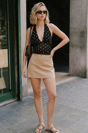 Falda short de fit ajustado, cintura alta, vivos decorativos posteriores y cierre lateral con cremallera oculta.