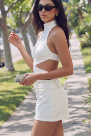 Falda short corto de cintura media, fit ajustado y cinturón decorativo con hebilla en contraste. Cierre lateral con cremallera oculta.