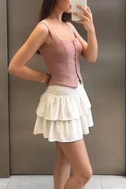 Falda short de corte en a, cintura alta elástica con pretina fruncida y capas de olanes en bajo.