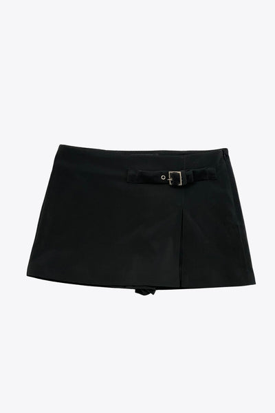 Falda short corto de fit recto, cintura alta, trabilla decorativa con hebilla en contraste, abertura frontal en bajo y cierre lateral con cremallera oculta.