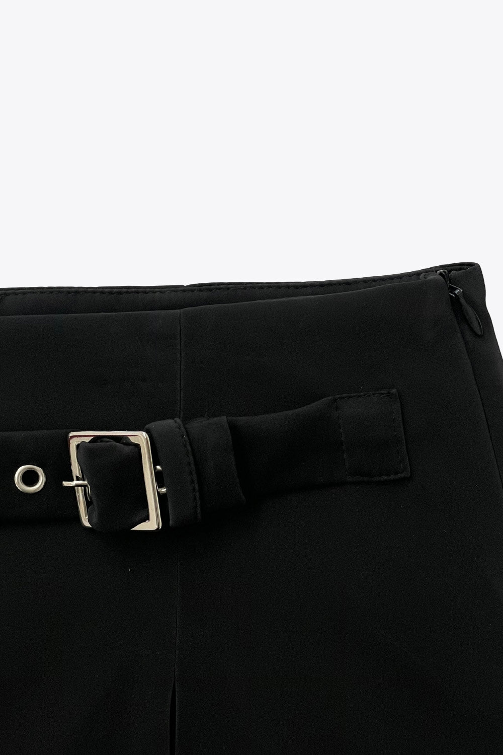 Falda short corto de fit recto, cintura alta, trabilla decorativa con hebilla en contraste, abertura frontal en bajo y cierre lateral con cremallera oculta.