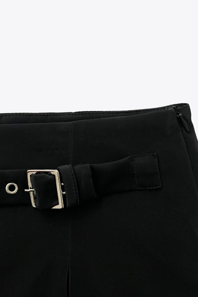 Falda short corto de fit recto, cintura alta, trabilla decorativa con hebilla en contraste, abertura frontal en bajo y cierre lateral con cremallera oculta.