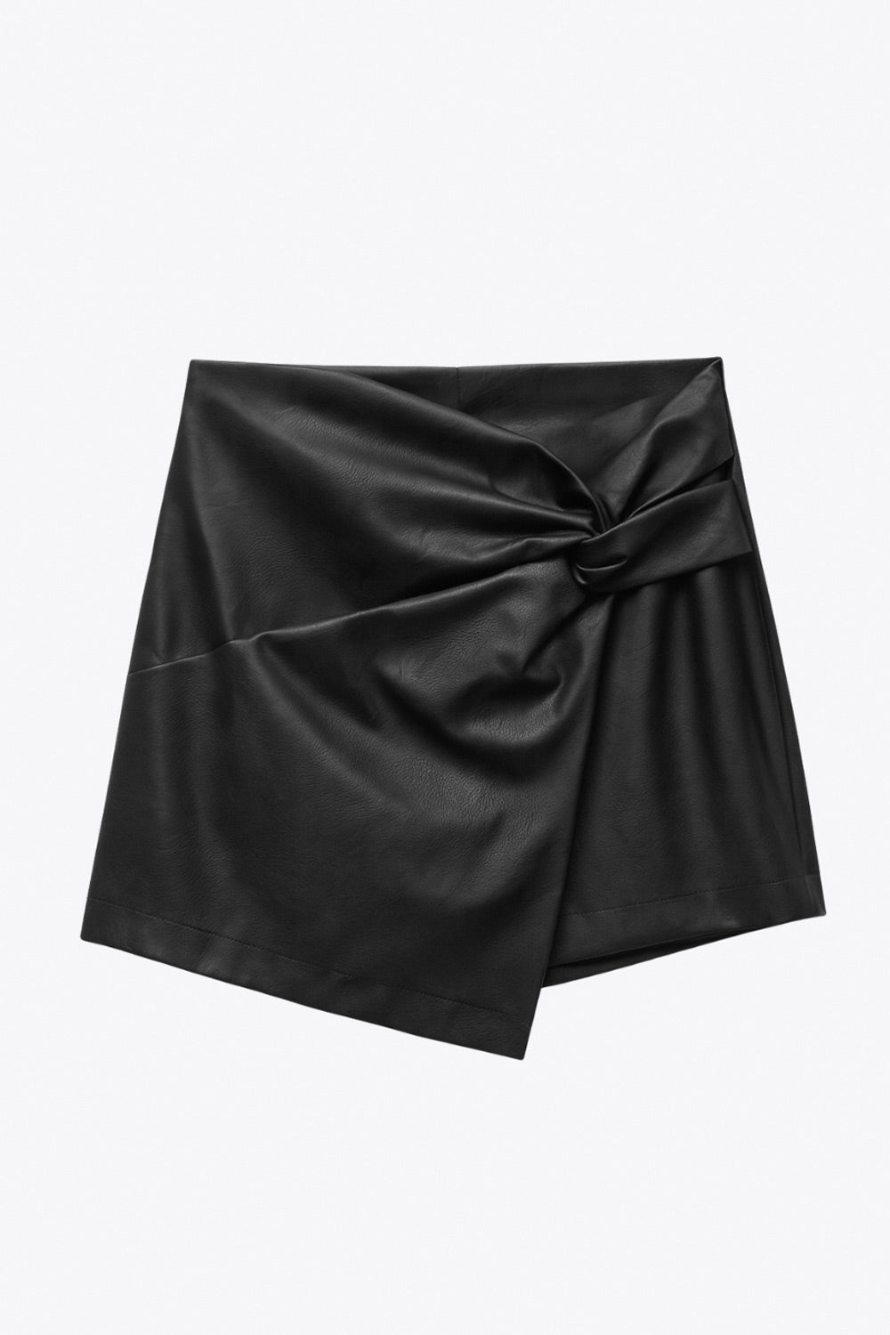 Falda short corto de efecto piel, fit ajustado, cintura alta, cruce frontal asimétrico con nudo y plisados decorativos frontales. Cierre posterior con cremallera oculta.