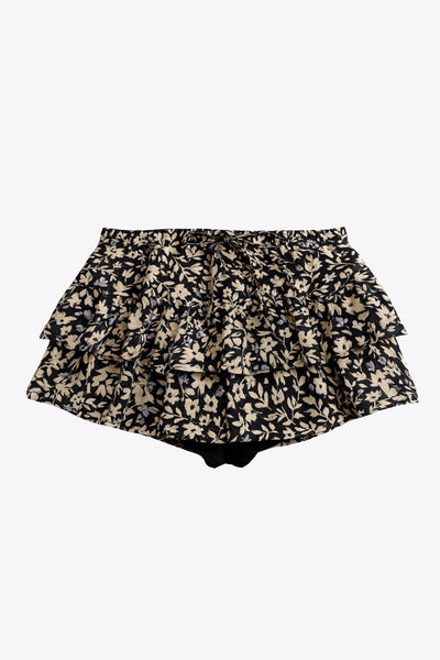Falda short corto de estampado floral, cintura baja con pretina y jareta frontal ajustable, corte en a y capas de olanes en bajo.