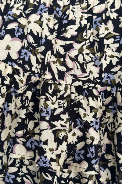 Falda short corto de estampado floral, cintura baja con pretina y jareta frontal ajustable, corte en a y capas de olanes en bajo.