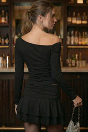 Falda short corto de cintura alta con pretina con plisados decorativos laterales, corte en a y bajo con capas de olanes. Cierre lateral con cremallera oculta.