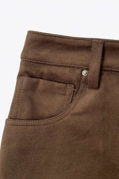 Falda short corto de gamuza, fit ajustado, cintura alta con pretina y trabillas, bolsillos delanteros, cierre frontal con botón y cremallera oculta.