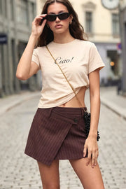 Falda corto de estampado rayas, cintura alta con pretina criss cross y trabillas, corte en a, cruce frontal asimétrico y cierre frontal con botón en contraste.